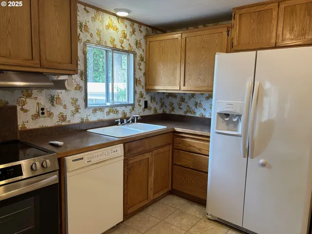 a kitchen with a refrigerator sink and cabinets