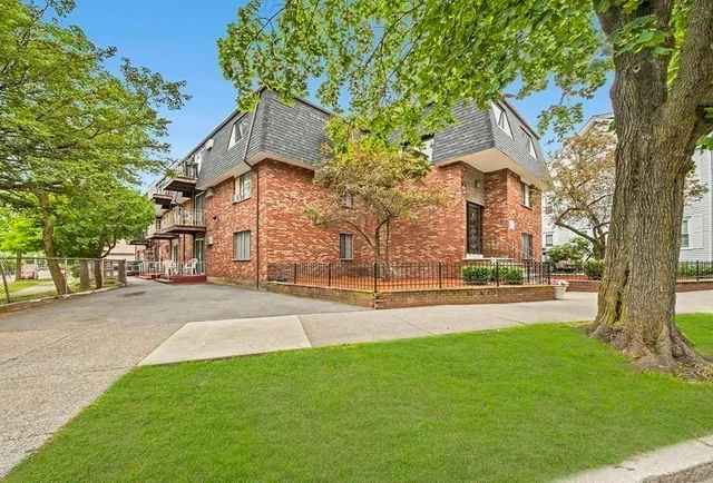 front view of a house with a yard and an trees