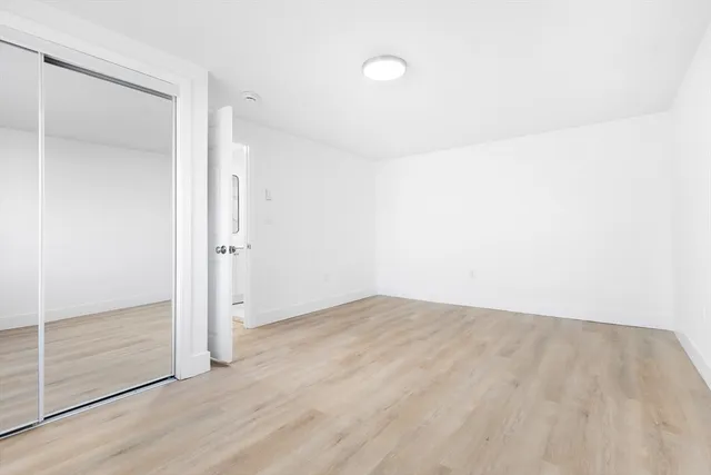 an empty room with wooden floor and sliding door
