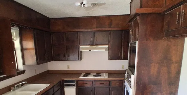 a stove top oven sitting inside of a kitchen