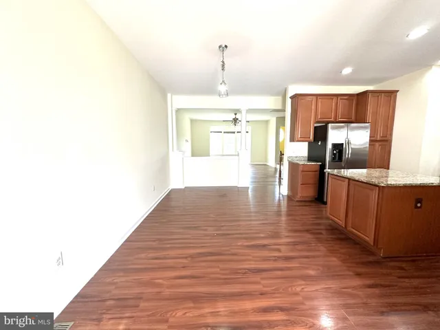 a kitchen with granite countertop a stove and a wooden floors