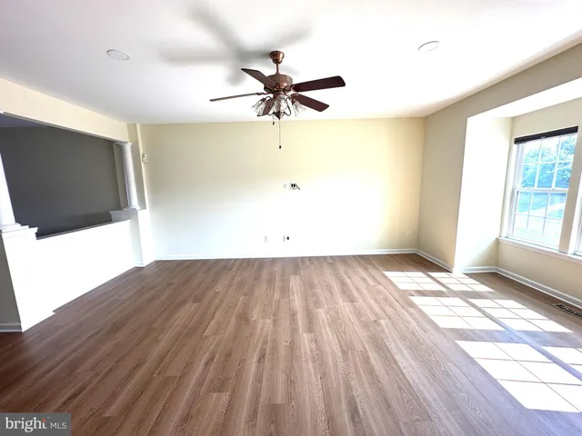 a view of a room with wooden floor and windows