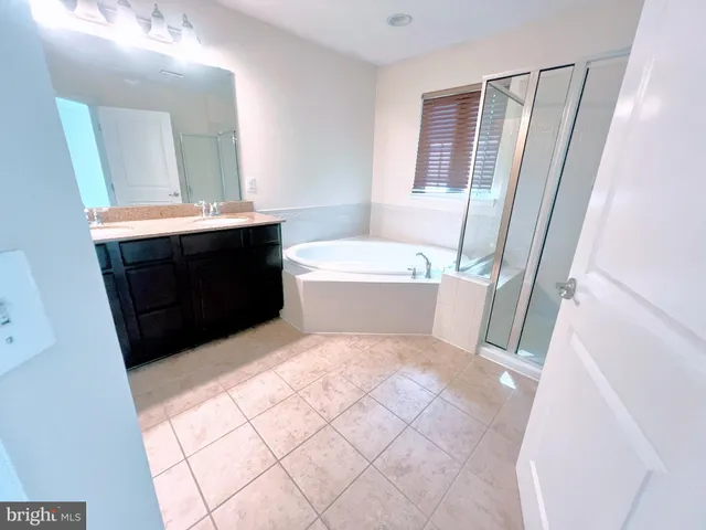 a bathroom with a bathtub sink vanity and a mirror