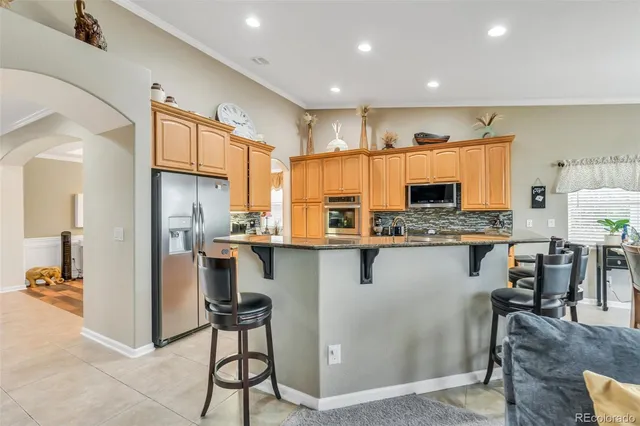 a kitchen with stainless steel appliances kitchen island granite countertop a refrigerator and a stove top oven