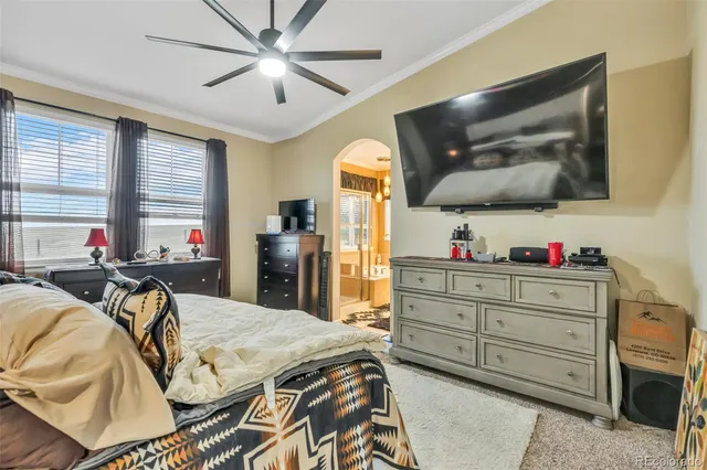 a bed room with a bed a television and a large window