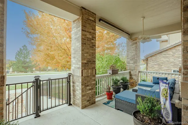 a view of a balcony with chairs and iron fence