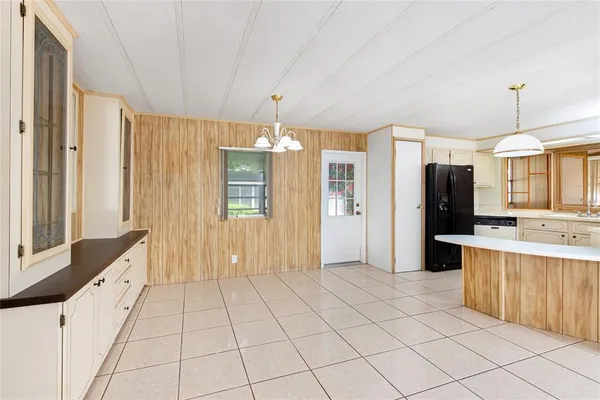 a view of a kitchen with kitchen island granite countertop a refrigerator and a sink