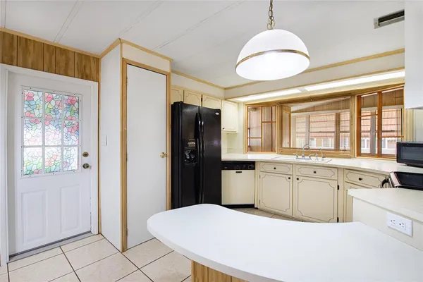 a kitchen with granite countertop a refrigerator a sink dishwasher a stove with wooden cabinets and floor