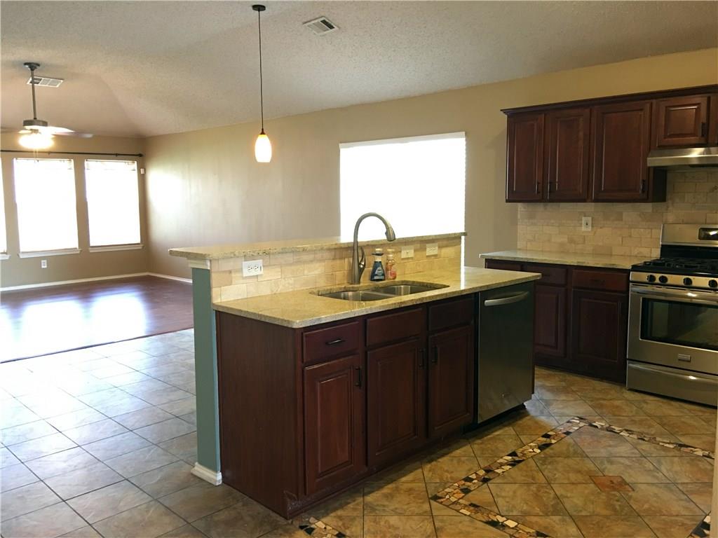 6740 Red Rock Trail Watauga, TX 76137 - Photo 5 of 16 a kitchen with a sink and wooden cabinets