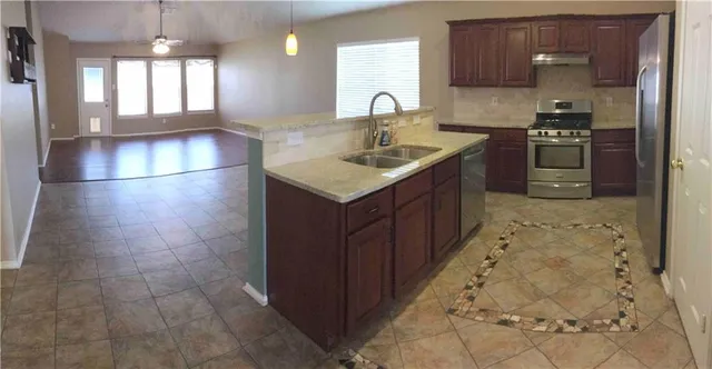 a kitchen with a sink stove and cabinets