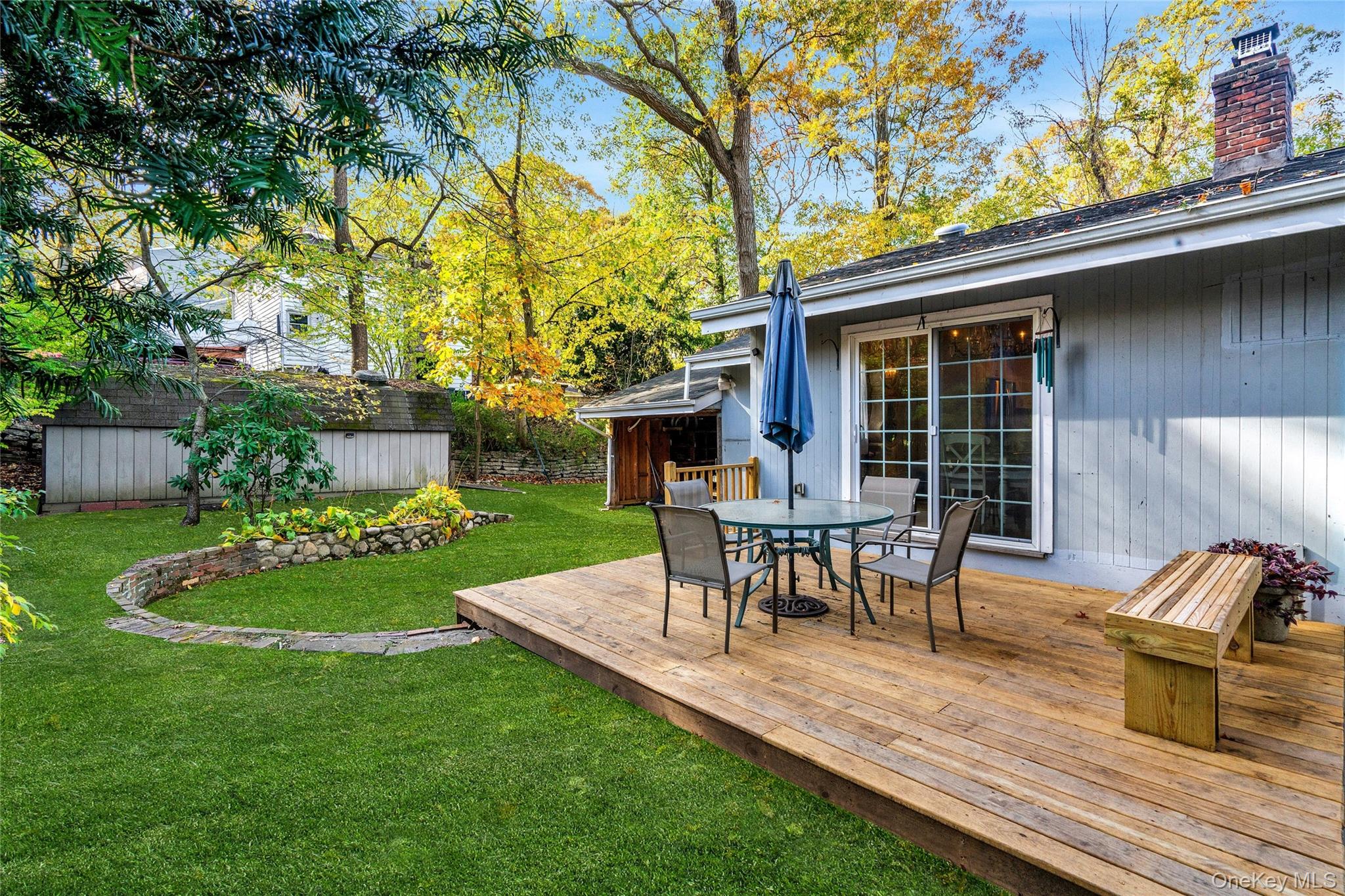 121 Grove Road Kings Park, NY 11754 - Photo 20 of 24 a view of a backyard with table and chairs potted plants and a large tree
