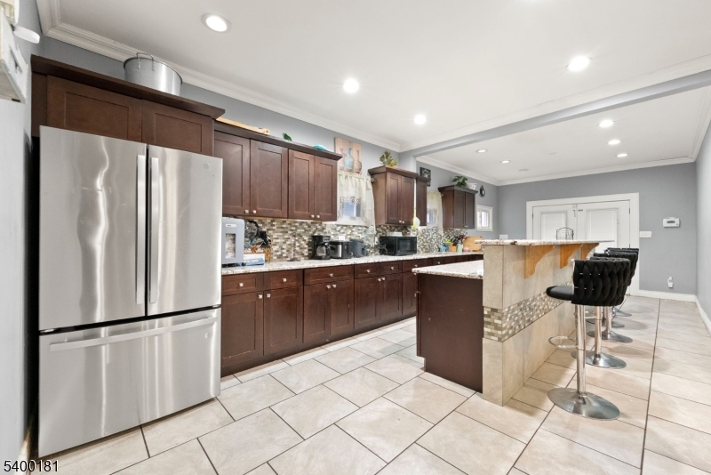 263 Stiles Street Elizabeth, NJ 07208 - Photo 11 of 30 a kitchen with stainless steel appliances a refrigerator sink and cabinets