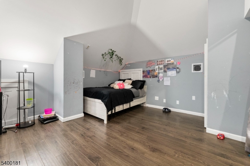 263 Stiles Street Elizabeth, NJ 07208 - Photo 23 of 30 a spacious bedroom with a bed and a wooden floor