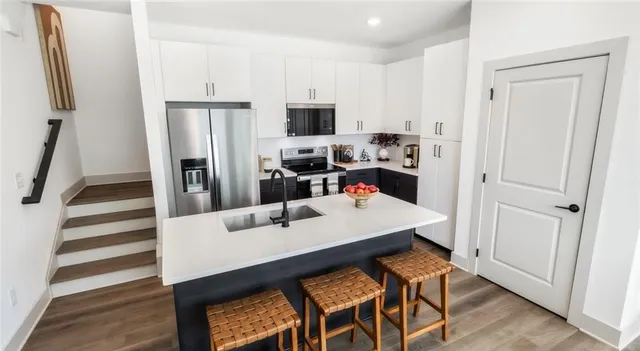 a kitchen with white cabinets and stainless steel appliances