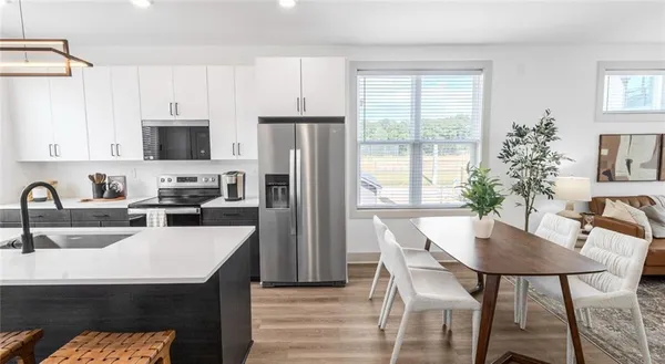 a kitchen with a table chairs refrigerator and microwave