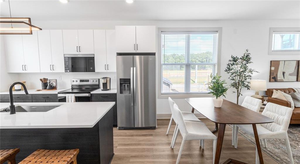 277 Clifton Street Southeast, Unit A1 Atlanta, GA 30317 - Photo 8 of 30 a kitchen with a table chairs refrigerator and microwave