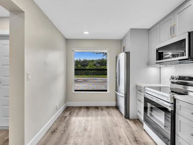 a kitchen with stainless steel appliances a sink a refrigerator and a counter top space