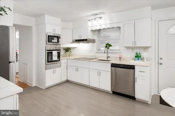 a kitchen with white cabinets and white appliances