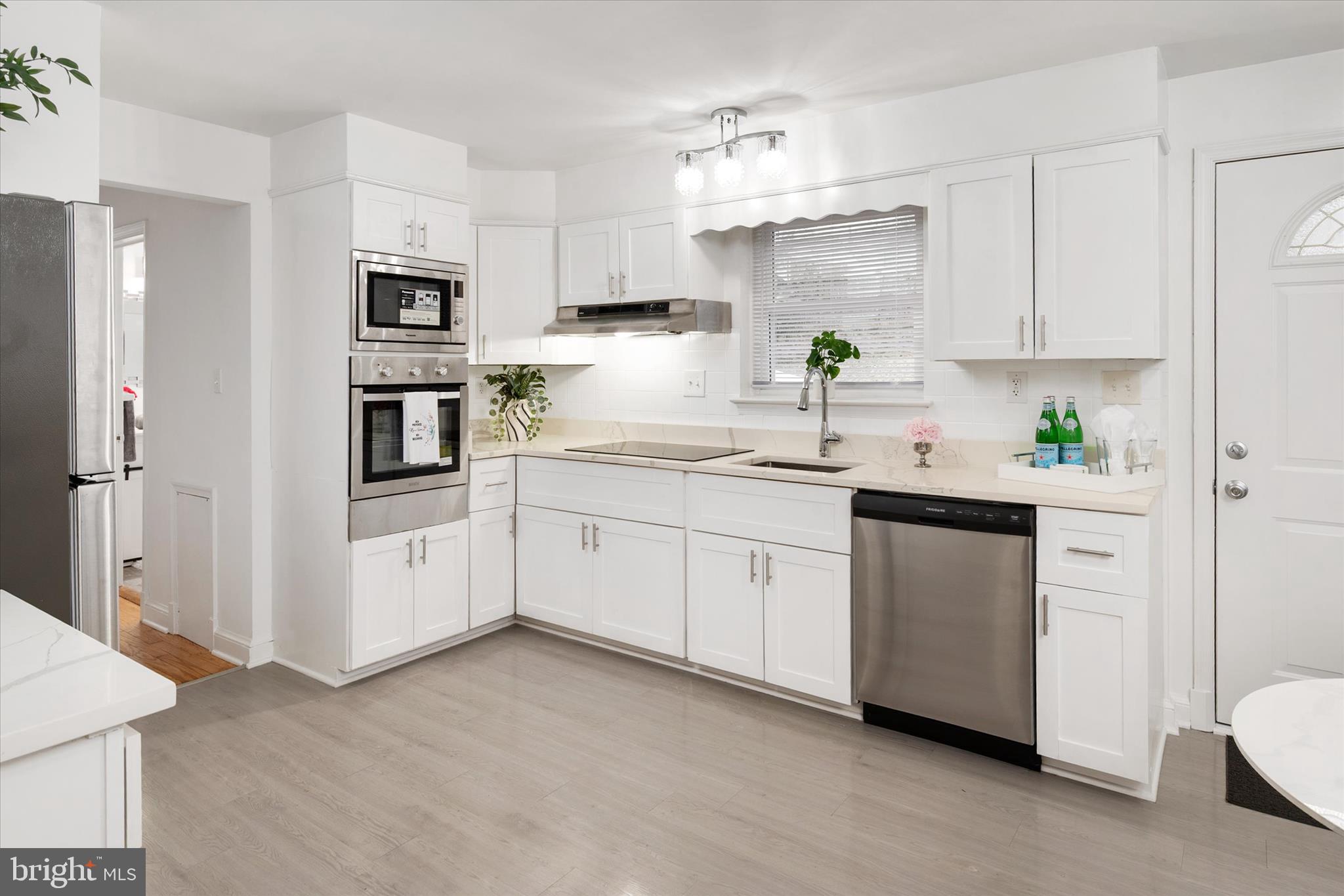11006 Childs Street Silver Spring, MD 20901 - Photo 11 of 42 a kitchen with white cabinets and white appliances