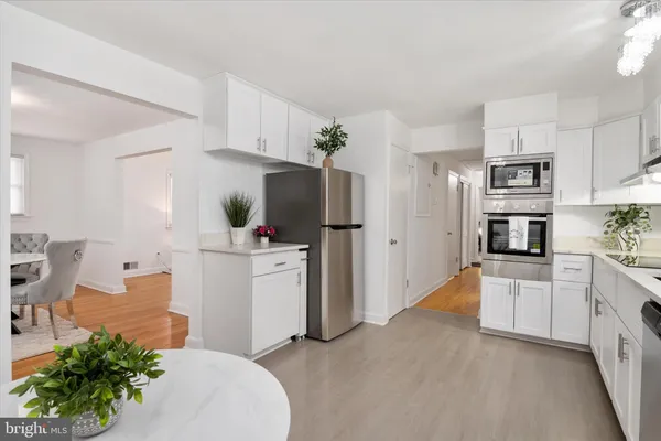 a kitchen with white cabinets and stainless steel appliances