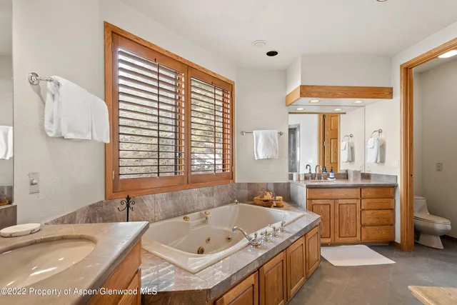 a spacious bathroom with a granite countertop tub sink and mirror