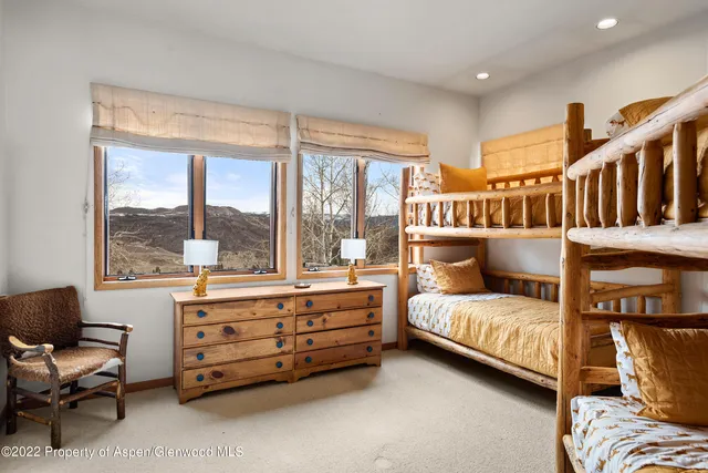 a bedroom with furniture and a large window