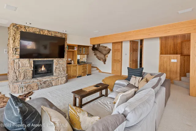 a living room with furniture a flat screen tv and a fireplace