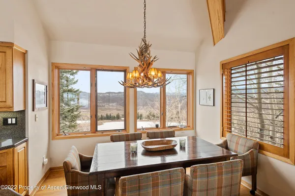 a dining room with furniture a large window and a chandelier