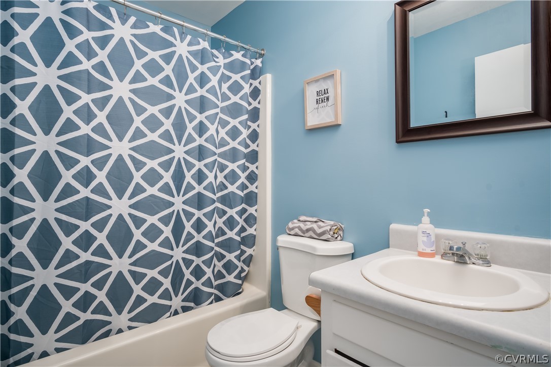 15948 Sandwave Road Chester, VA 23831 - Photo 13 of 22 a bathroom with a white toilet sitting next to a white sink and a shower curtain