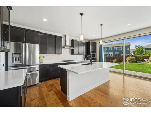 a kitchen with stainless steel appliances granite countertop a sink a stove and a refrigerator