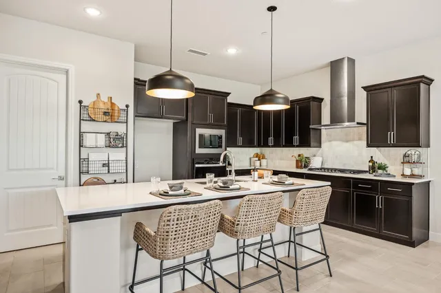 a kitchen with a dining table cabinets and stainless steel appliances