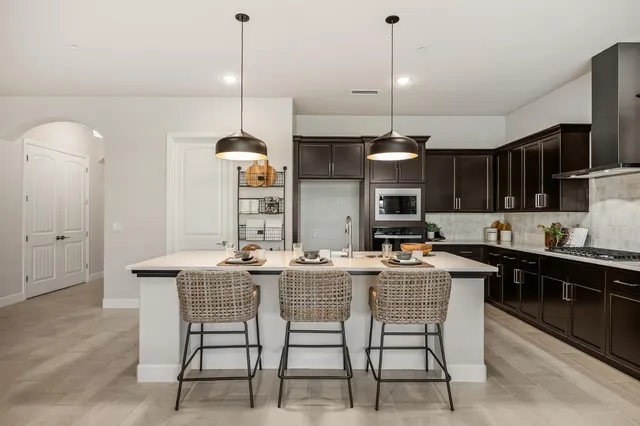 a kitchen with a dining table chairs and white cabinets