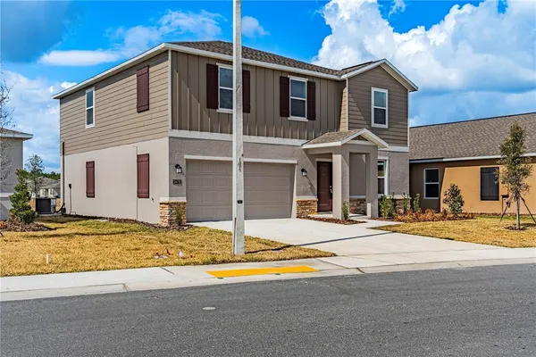 a view of a white house with swimming pool and sitting area