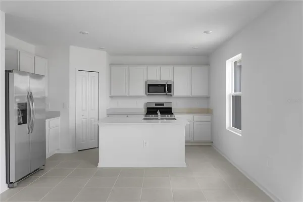 a kitchen with cabinets and a refrigerator