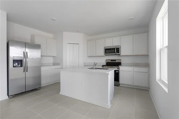 a kitchen with cabinets stainless steel appliances and a window