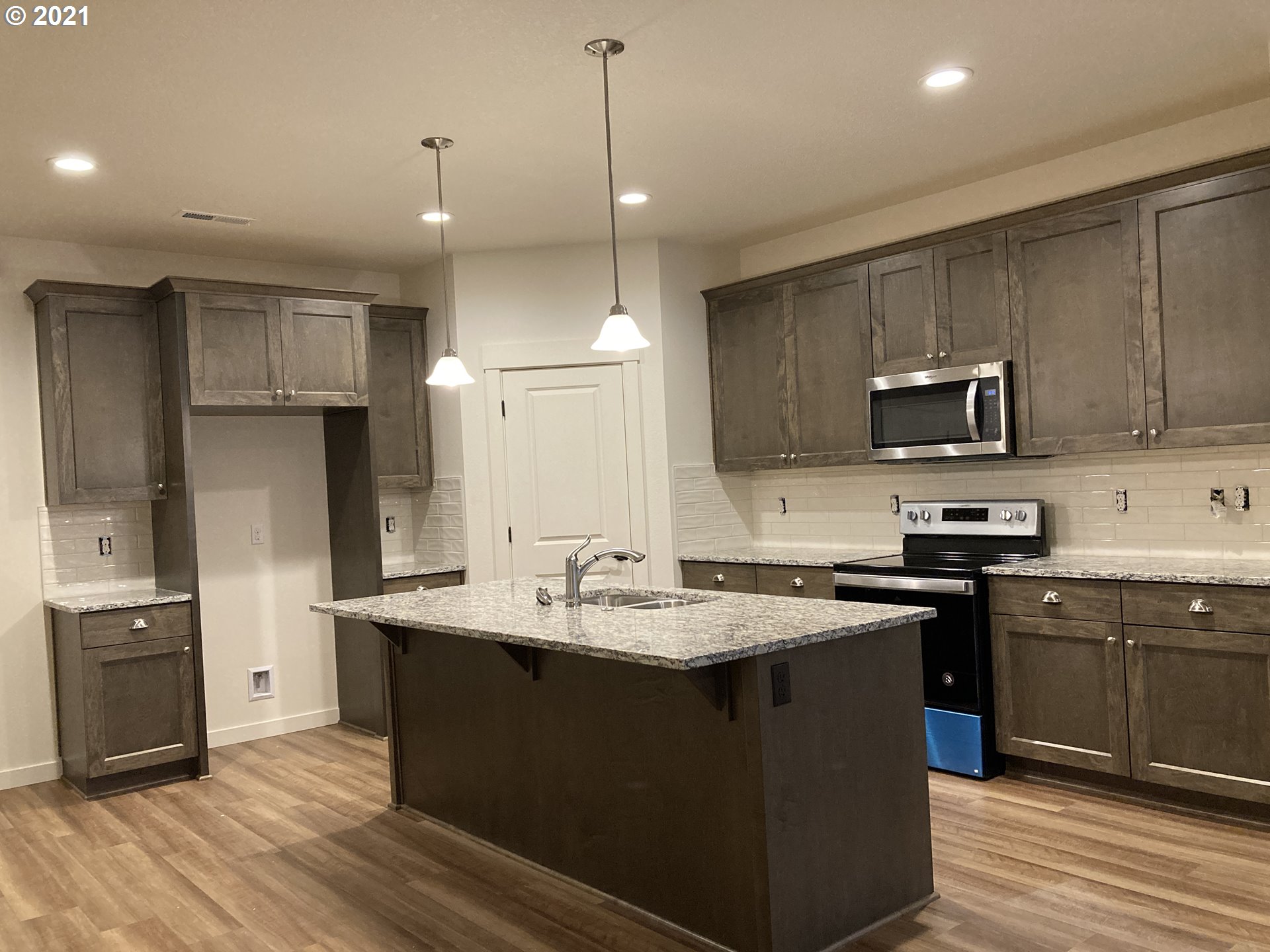 7031 South Ridge Way Ridgefield, WA 98642 - Photo 3 of 14 a kitchen with a sink a stove a refrigerator and cabinets
