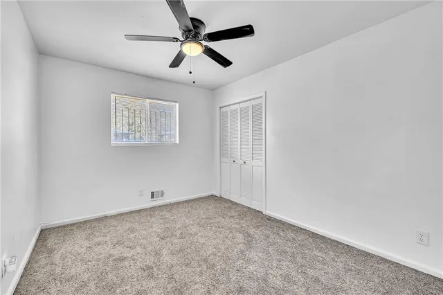a view of room with ceiling fan and window
