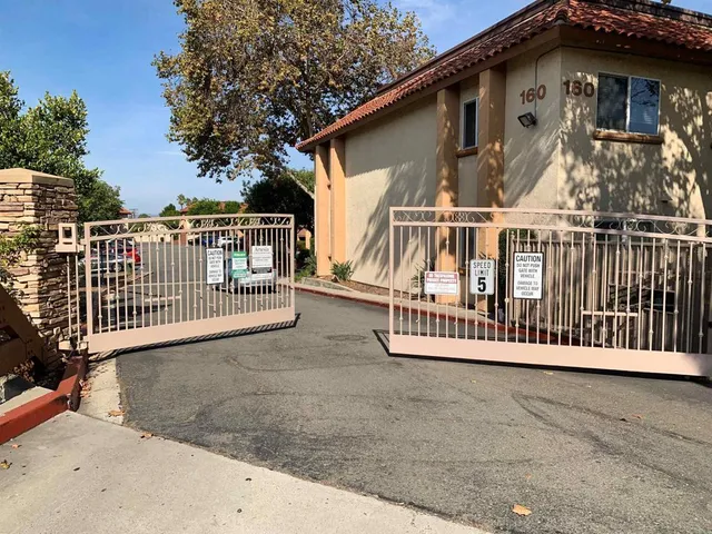 a view of a house with a small yard and wooden fence