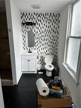 a bathroom with a toilet and a mirror