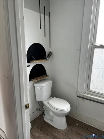 a white toilet sitting next to a window