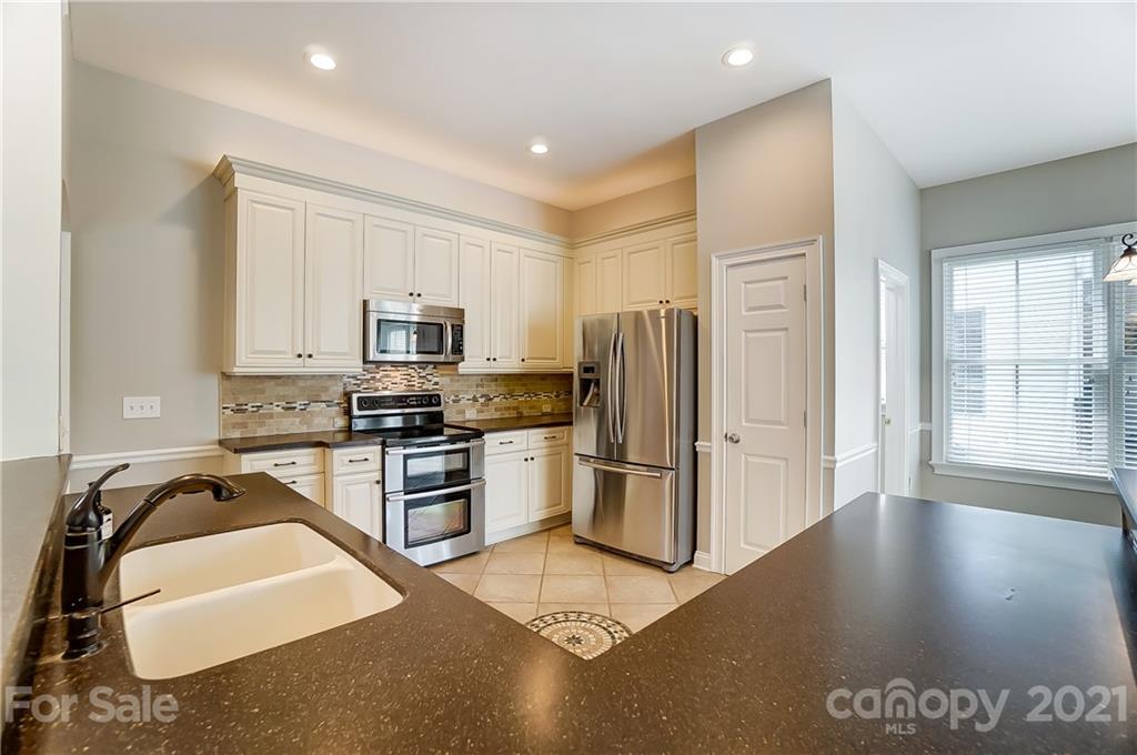 3233 Colonel Springs Way Fort Mill, SC 29708 - Photo 13 of 48 a kitchen with granite countertop a refrigerator and a stove top oven