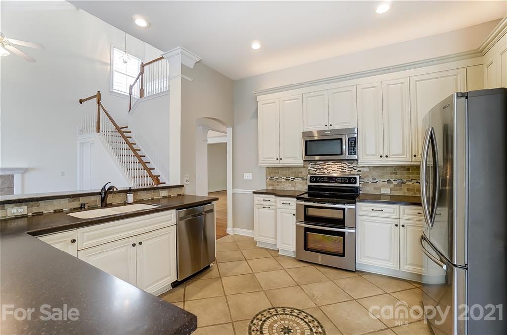 3233 Colonel Springs Way Fort Mill, SC 29708 - Photo 16 of 48 a kitchen with stainless steel appliances granite countertop a sink stove oven and refrigerator