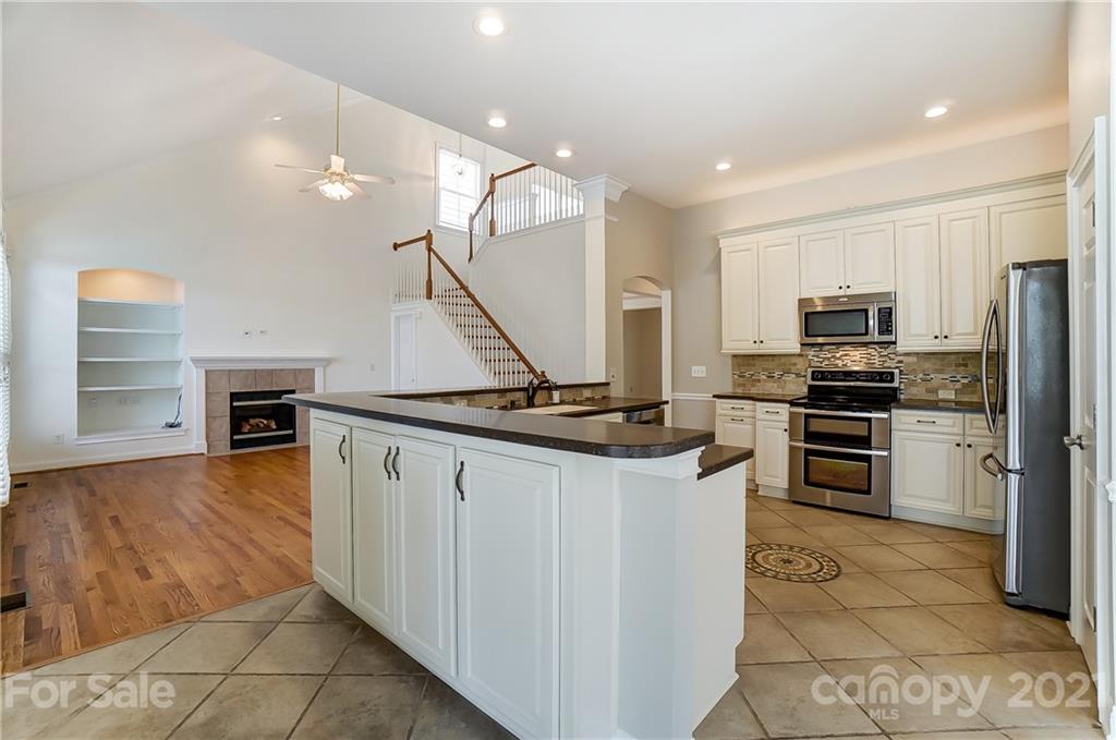 3233 Colonel Springs Way Fort Mill, SC 29708 - Photo 17 of 48 a kitchen with stainless steel appliances kitchen island granite countertop a refrigerator and a stove top oven