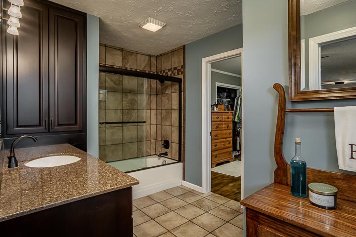 757 Robinson Ridge Road Baxter, TN 38544 - Photo 12 of 26 a bathroom with a granite countertop sink and a shower