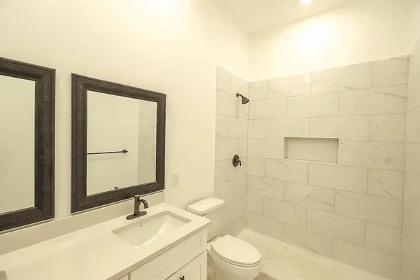 a bathroom with a sink a toilet and shower