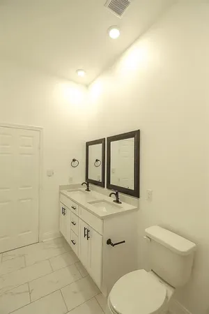 a bathroom with a toilet sink and mirror