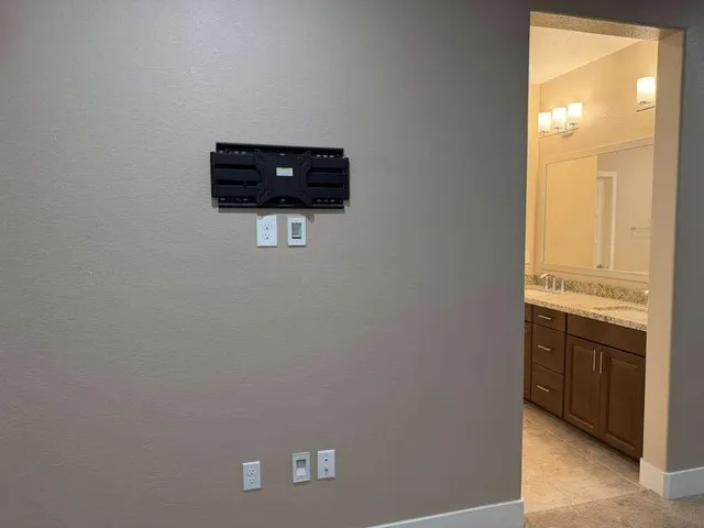a bathroom with a granite countertop sink a light fixture and a mirror