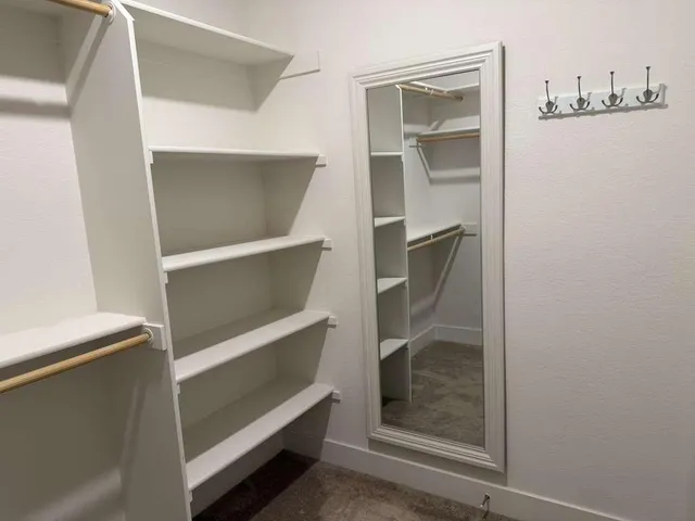 a view of walk in closet with empty racks