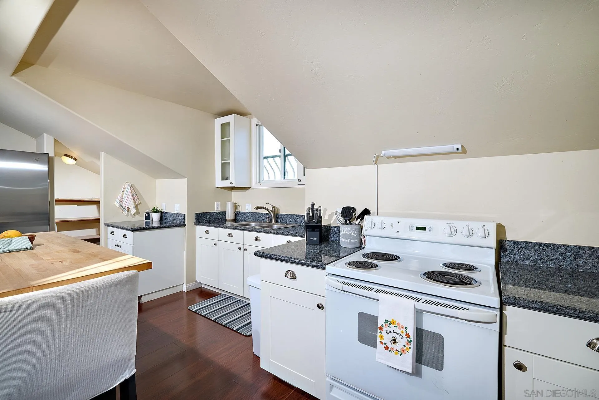 38408 Mesa Road Temecula, CA 92592 - Photo 32 of 57 a kitchen with sink a stove and white cabinets with wooden floor