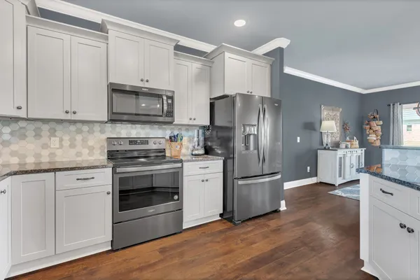 a kitchen with stainless steel appliances granite countertop a refrigerator stove and sink